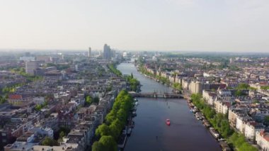 Amsterdam, Hollanda. Şehrin çatılarında uçuyor. Amstel Nehri. 4k