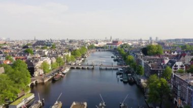 Amsterdam, Hollanda. Şehrin çatılarında uçuyor. Amstel Nehri, Amstel Geçidi. 4K