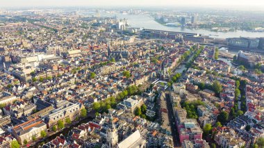 Amsterdam, Hollanda. Amsterdam Merkez İstasyonu (Amsterdam Centraal) doğru şehir çatıları üzerinde Uçan , Havadan Görünümü 