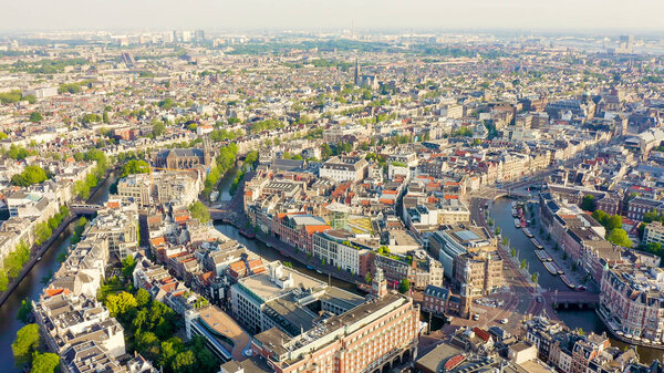 Amsterdam, Netherlands. Flying over the city rooftops. The historical part of the city with urban shipping channels, Aerial View