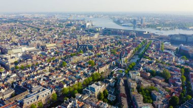 Amsterdam, Hollanda. Amsterdam Merkez İstasyonu (Amsterdam Centraal) doğru şehir çatıları üzerinde Uçan , Havadan Görünümü 