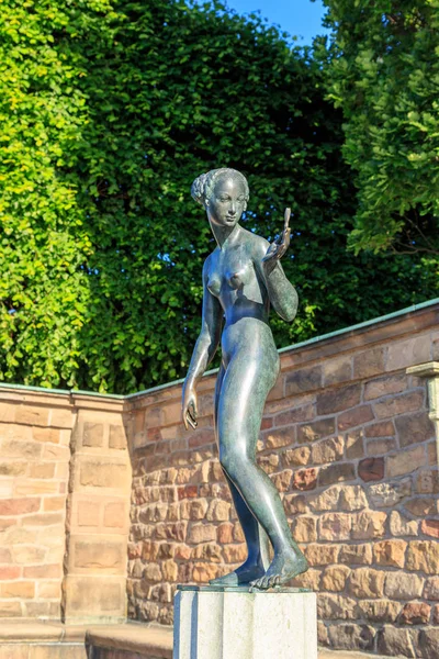 Stockholm, Sweden. Sculpture of a naked girl looking at a flower — Stock Photo, Image
