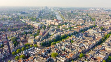 Amsterdam, Hollanda. Amsterdam Merkez İstasyonu (Amsterdam Centraal) doğru şehir çatıları üzerinde Uçan , Havadan Görünümü 
