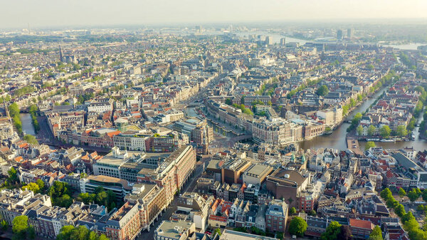 Amsterdam, Netherlands. Flying over the city rooftops. The historical part of the city with urban shipping channels, Aerial View