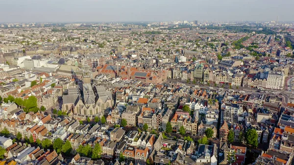 Amsterdam, Netherlands. Flying over the city rooftops towards Amsterdam Central Station ( Amsterdam Centraal ) and around the Oudekerk church ( De Oude Kerk ), Aerial View — Stock Photo, Image