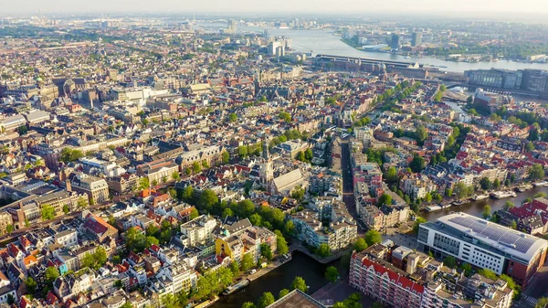Amsterdam, Netherlands. Vliegen over de daken van de stad richting Amsterdam Centraal station (Amsterdam Centraal), bovenaanzicht — Stockfoto