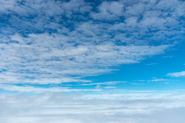 Bulutlar ve mavi gökyüzü arka plan, bir uçak penceresinden incelendi.