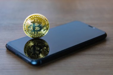 Akıllı telefon ekranı ile Bitcoin sikke.