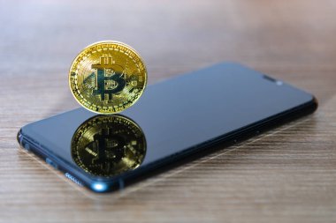 Akıllı telefon ekranı ile Bitcoin sikke.