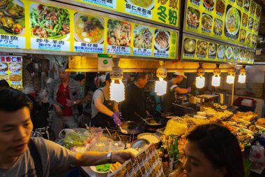 Shilin Gece Pazarı yemek mahkemesi. Popüler ve ünlü bir yer, sonsuz gıda tezgahları, kalabalıklar. Tayvan'ın en büyük gece pazarı, insanlar burada yemek, içki ve alışveriş olsun. Taipei, Tayvan - 15 Nisan 2019.