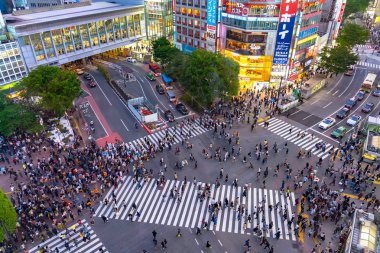 Shibuya Crossing dünyanın en işlek yaya geçitlerinden biridir. Shibuya semtinde yayalar yaya geçidine giriyor. Tokyo, Japonya - 3 Mayıs 2019