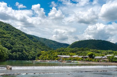Arashiyama ilçesinde renkli orman dağ arka plan ile katsuragawa nehri üzerinde Togetsu-kyo köprü. Arashiyama, ulusal olarak belirlenmiş tarihi bir yer ve Doğal Güzellik Yeridir. Kyoto, Japonya