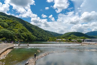 Arashiyama ilçesinde renkli orman dağ arka plan ile katsuragawa nehri üzerinde Togetsu-kyo köprü. Arashiyama, ulusal olarak belirlenmiş tarihi bir yer ve Doğal Güzellik Yeridir. Kyoto, Japonya