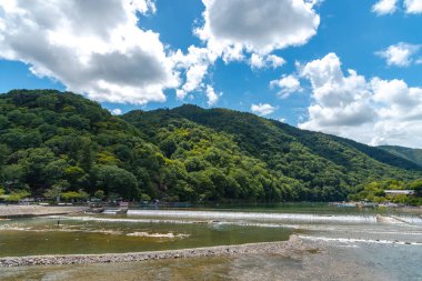 Arashiyama ilçesinde renkli orman dağ arka plan ile katsuragawa nehri üzerinde Togetsu-kyo köprü. Arashiyama, ulusal olarak belirlenmiş tarihi bir yer ve Doğal Güzellik Yeridir. Kyoto, Japonya