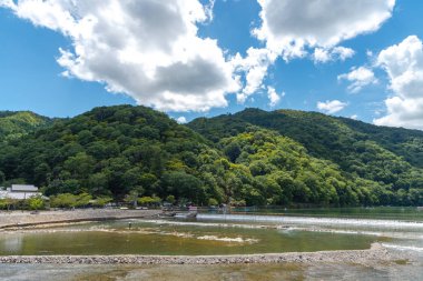 Arashiyama ilçesinde renkli orman dağ arka plan ile katsuragawa nehri üzerinde Togetsu-kyo köprü. Arashiyama, ulusal olarak belirlenmiş tarihi bir yer ve Doğal Güzellik Yeridir. Kyoto, Japonya