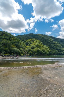 Arashiyama ilçesinde renkli orman dağ arka plan ile katsuragawa nehri üzerinde Togetsu-kyo köprü. Arashiyama, ulusal olarak belirlenmiş tarihi bir yer ve Doğal Güzellik Yeridir. Kyoto, Japonya