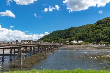 Arashiyama ilçesinde renkli orman dağ arka plan ile katsuragawa nehri üzerinde Togetsu-kyo köprü. Arashiyama, ulusal olarak belirlenmiş tarihi bir yer ve Doğal Güzellik Yeridir. Kyoto, Japonya