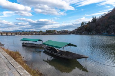 Hozu-gawa Nehri ve Togetsu-kyo köprü de Tekne Arashiyama renkli orman dağ arka plan ile, Kyoto, Japonya. Arashiyama ulusal olarak belirlenmiş tarihi bir yer ve Manzara Güzellik Yeri.