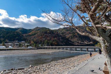 Arashiyama ilçesinde renkli orman dağ arka plan ile katsuragawa nehri üzerinde Togetsu-kyo köprü. Arashiyama, ulusal olarak belirlenmiş tarihi bir yer ve Doğal Güzellik Yeridir. Kyoto, Japonya