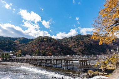 Arashiyama ilçesinde renkli orman dağ arka plan ile katsuragawa nehri üzerinde Togetsu-kyo köprü. Arashiyama, ulusal olarak belirlenmiş tarihi bir yer ve Doğal Güzellik Yeridir. Kyoto, Japonya