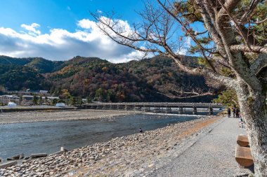 Arashiyama ilçesinde renkli orman dağ arka plan ile katsuragawa nehri üzerinde Togetsu-kyo köprü. Arashiyama, ulusal olarak belirlenmiş tarihi bir yer ve Doğal Güzellik Yeridir. Kyoto, Japonya