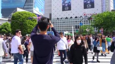 Shibuya Geçidi'nde ve gündüz (4k Uhd) yaya yürüyüşü ve fotoğraf çekme. Shibuya semtinde normal hızda yayaların yaya ların manzarası. Tokyo, Japonya - 4 Mayıs 2019