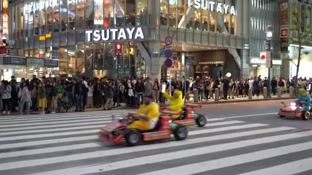 渋谷クロッシング(4k Uhd)を走るマリオカート。渋谷区、原宿、表参道など、有名なショッピングや観光スポットを巡るゴーカートを観光客が借りています。東京、日本。2019年5月4日 — ストック動画