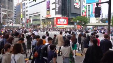 Tokyo, Japonya - 4 Mayıs 2019 : Shibuya Geçidi'nde gündüz yürüyen yaya ( 4k Uhd ). Shibuya semtinde normal hızda yayaların yaya geçidi görünümü.