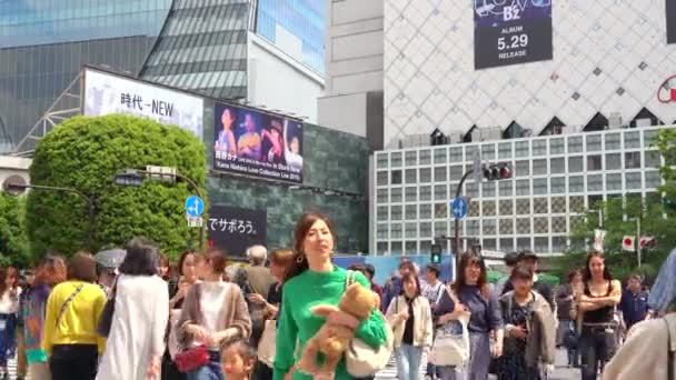 Токио, Япония - 4 мая 2019 года: Крупный план пешеходной прогулки по переходу Сибуя в дневное время (4K UHD). Камера с большой скоростью — стоковое видео