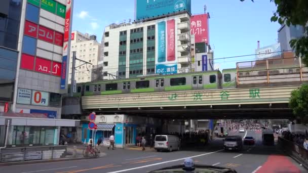 Токио, Япония - 4 мая 2019 года: Крупный план пешеходной прогулки по переходу Сибуя в дневное время (4K UHD). камера панорамирование справа налево, селективное фокусирование нормальной скорости — стоковое видео