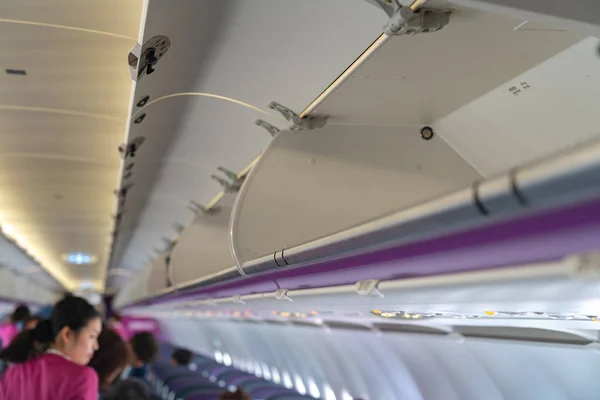 Carry-on luggage in overhead storage compartment on commercial airplane. detail shot of an airplane cabin interior. Travel concept with copy space