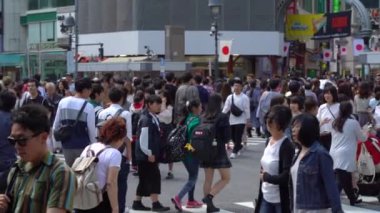 Tokyo, Japonya - 4 Mayıs 2019 : Shibuya Geçidi'nde gündüz yürüyen yayaları kapatın ( Slow Motion Video ). Kamera soldan sağa kaydırma, seçici odak