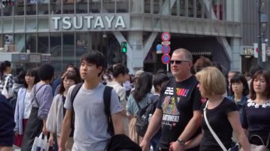 Tokyo, Japonya - 4 Mayıs 2019 : Shibuya Geçidi'nde gündüz yürüyen yayaları kapatın ( Slow Motion Video ). Kamera sağdan sola kaydırma, seçici odak