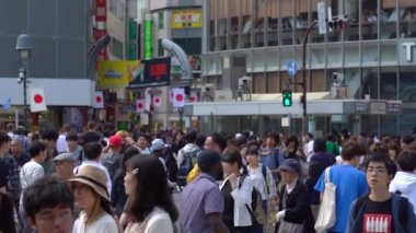 Tokyo, Japonya - 4 Mayıs 2019 : Shibuya Geçidi'nde gündüz yürüyen yayaları kapatın ( Slow Motion Video ). Kamera uzun çekim, seçici odak