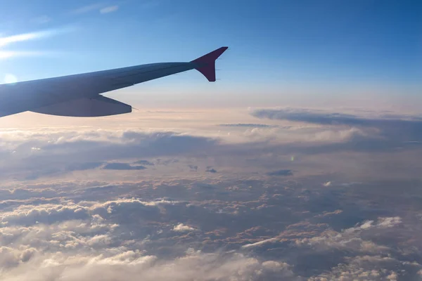 Πάνω στον αέρα, θέα της σιλουέτας του αεροσκάφους με σκούρο μπλε ορίζοντα του ουρανού και σύννεφο φόντο στο χρόνο Ανατολή του ήλιου, που προβάλλονται από το παράθυρο του αεροπλάνου — Φωτογραφία Αρχείου