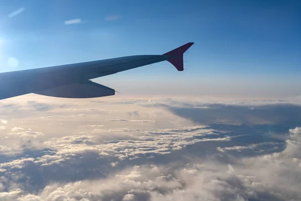 Arriba en el aire, vista de la silueta del ala del avión con el horizonte azul oscuro del cielo y el fondo de la nube en el tiempo de salida del sol, visto desde la ventana del avión —  Fotos de Stock