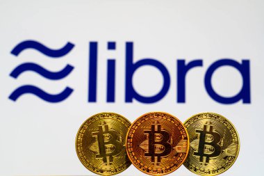 Arka plan ekranında Facebook Terazi Kripto Sikke logosu ile Altın Bitcoin Sikkeler. Tokyo, Japonya - 4 Temmuz 2019