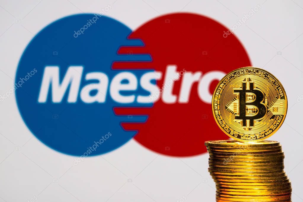 Gold Bitcoin coins with the MasterCard maestro logo on background screen. TOKYO, JAPAN - JULY 12, 2019