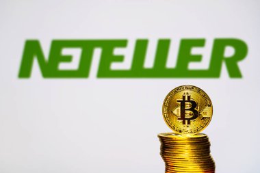 Arka plan ekranında Neteller logosu ile Altın Bitcoin sikkeler. Yeni bir iş finansmanı konsepti. Tokyo, Japonya - 28 Eylül 2019