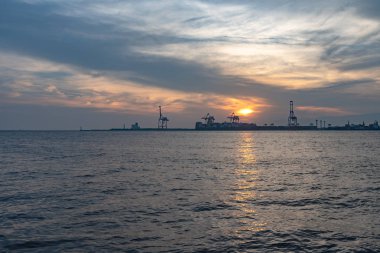 Yaz güneşi set zaman arka planda Yumeshima ada ile Osaka koyu, Osaka metro Cosmosquare tren istasyonu park gezinti görünümü