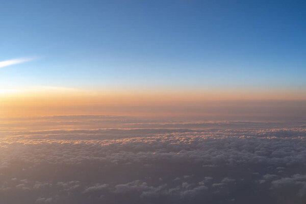 View of dark blue sky horizon in sun rise time, up in the air. viewed from an airplane window