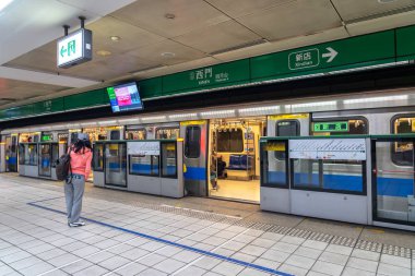 Taipei, Tayvan - 15 Nisan 2019 : Taipei metro istasyonu salonu ve platformu. Metro yolcuları Taipei Metro sisteminin muazzam yeraltı ağı üzerinden yürümek.