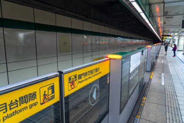 Taipei, Tayvan - 15 Nisan 2019 : Taipei metro istasyonu salonu ve platformu. Metro yolcuları Taipei Metro sisteminin muazzam yeraltı ağı üzerinden yürümek.