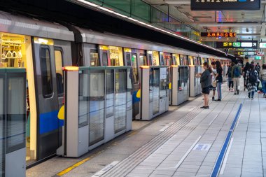 Taipei, Tayvan - 15 Nisan 2019 : Taipei metro istasyonu salonu ve platformu. Metro yolcuları Taipei Metro sisteminin muazzam yeraltı ağı üzerinden yürümek.