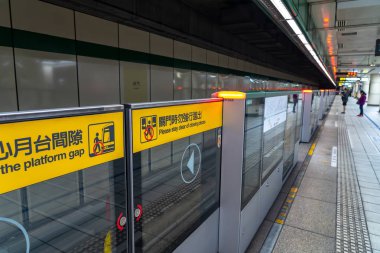Taipei, Tayvan - 15 Nisan 2019 : Taipei metro istasyonu salonu ve platformu. Metro yolcuları Taipei Metro sisteminin muazzam yeraltı ağı üzerinden yürümek.