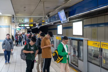 Taipei, Tayvan - 15 Nisan 2019 : Taipei metro istasyonu salonu ve platformu. Metro yolcuları Taipei Metro sisteminin muazzam yeraltı ağı üzerinden yürümek.