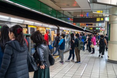 Taipei, Tayvan - 15 Nisan 2019 : Taipei metro istasyonu salonu ve platformu. Metro yolcuları Taipei Metro sisteminin muazzam yeraltı ağı üzerinden yürümek.