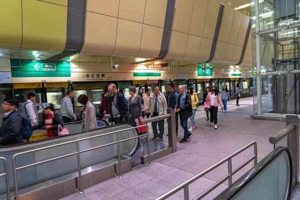 Taipei, Taiwán - 15 de abril de 2019: Salón y plataforma de la estación de metro de Taipei. Pasajeros del metro caminan a través de la enorme red subterránea del sistema de metro de Taipei . —  Fotos de Stock