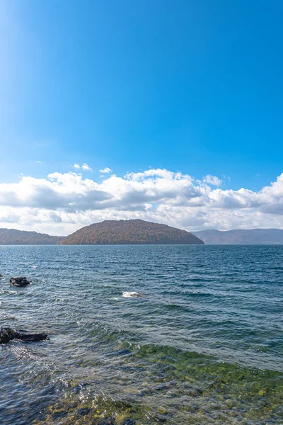 Hermosos paisajes de follaje otoñal. El otoño está lleno de magníficos colores. Vista desde la orilla del lago Towada, cielo azul claro y agua, nube blanca, fondo de día soleado. Prefectura de Aomori, Japón —  Fotos de Stock