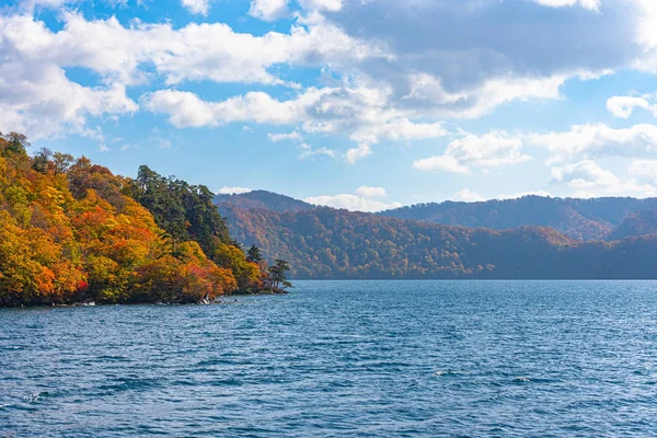 Güzel sonbahar yeşillik manzara manzaralar. Sonbahar muhteşem renklerle doludur. Towada Gölü gezi Cruise gemi görünümü. Berrak mavi gökyüzü, su, beyaz bulut, güneşli bir gün arka plan. Aomori, Japonya — Stok fotoğraf